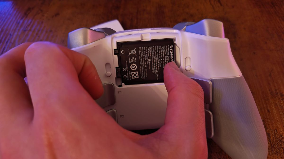 A reviewer takingout the battery of the SteelSeries Aeon Pro