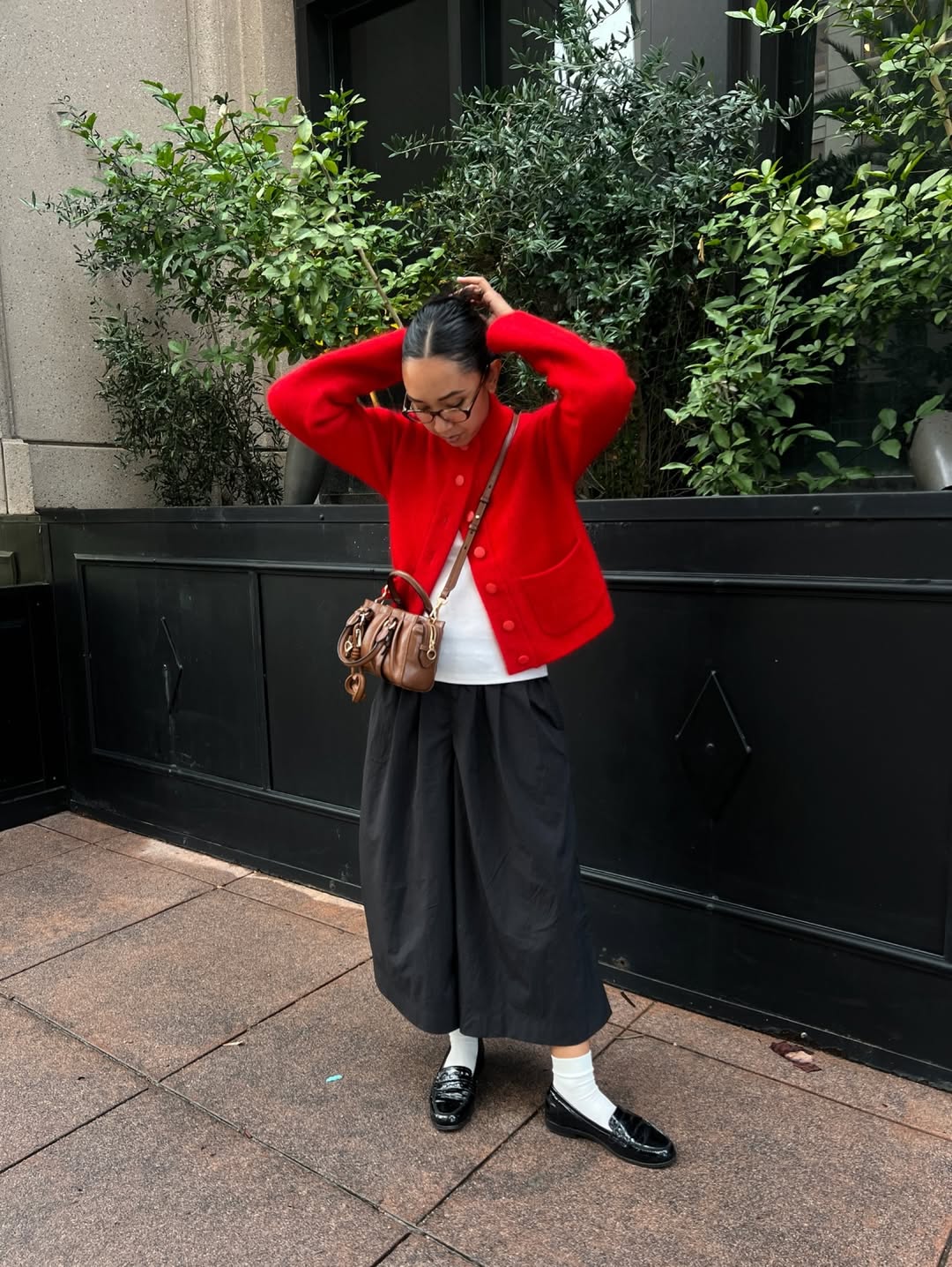 Influencer Stephanie Arant wearing culottes, a red cardigan and loafers.