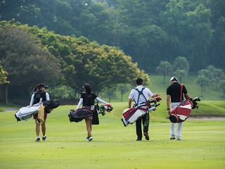 a four-ball of junior golfers walking down the fairway