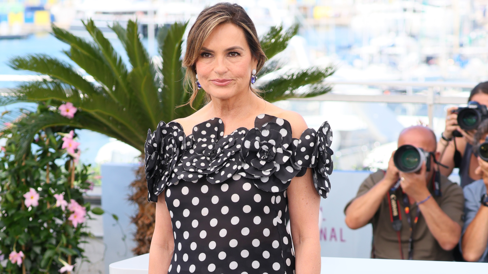 Mariska Hargitay wearing a low ponytail with a deep side part and few tendrils framing her face. She&#039;s also wear an off-the-shoulder polka dot dress. 