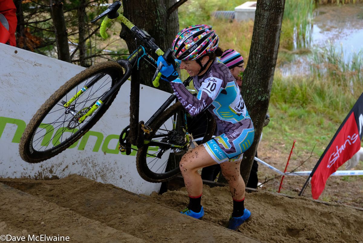Arley Kemmerer lifting her bike over a steep set of stairs during lap one