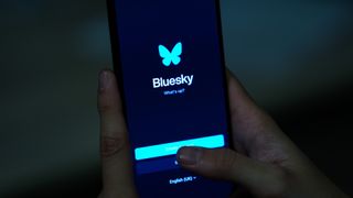 The BlueSky logo is displayed on a mobile phone screen with its icon in back of it