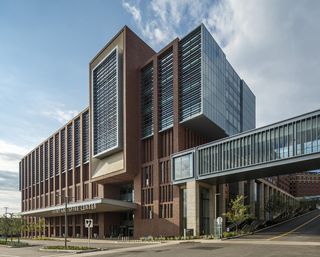 Exterior of the building, constructed using red brick and glass panels in a geometric design