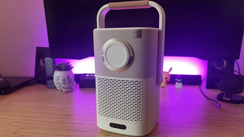 Yaber T2 projector with lens cap on on a wooden desk