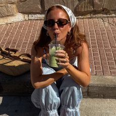 Creator @rebeccaferrazwyatt drinking a matcha latte in the sunshine