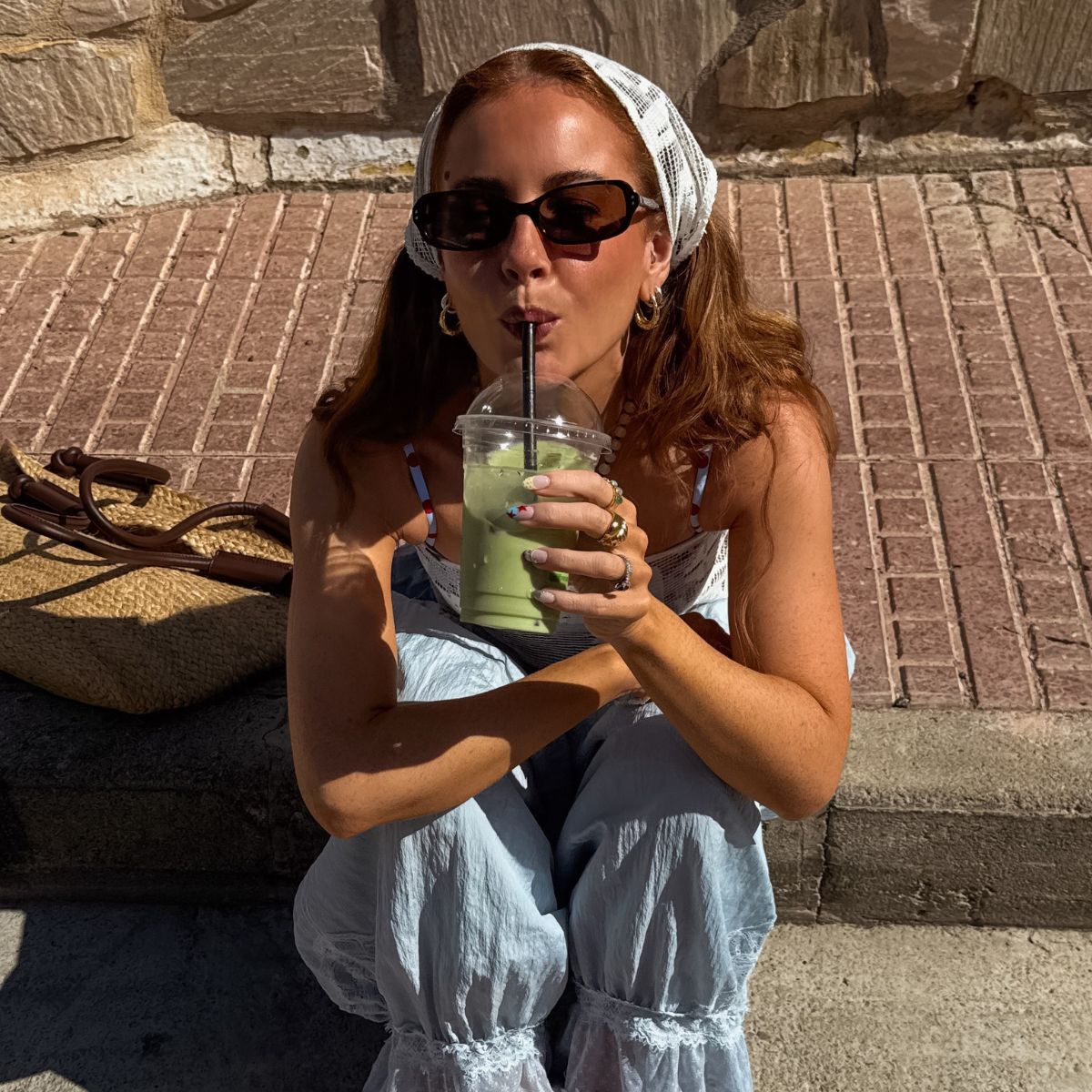 Creator @rebeccaferrazwyatt drinking a matcha latte in the sunshine