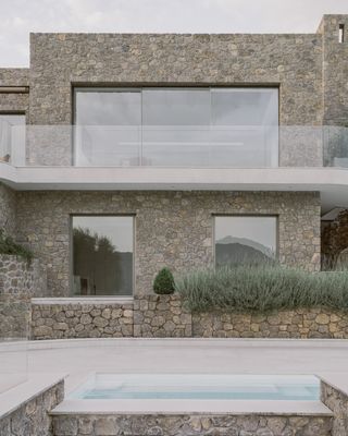 Corfu House minimalist interior and stone exterior with swimming pool looking to the sea