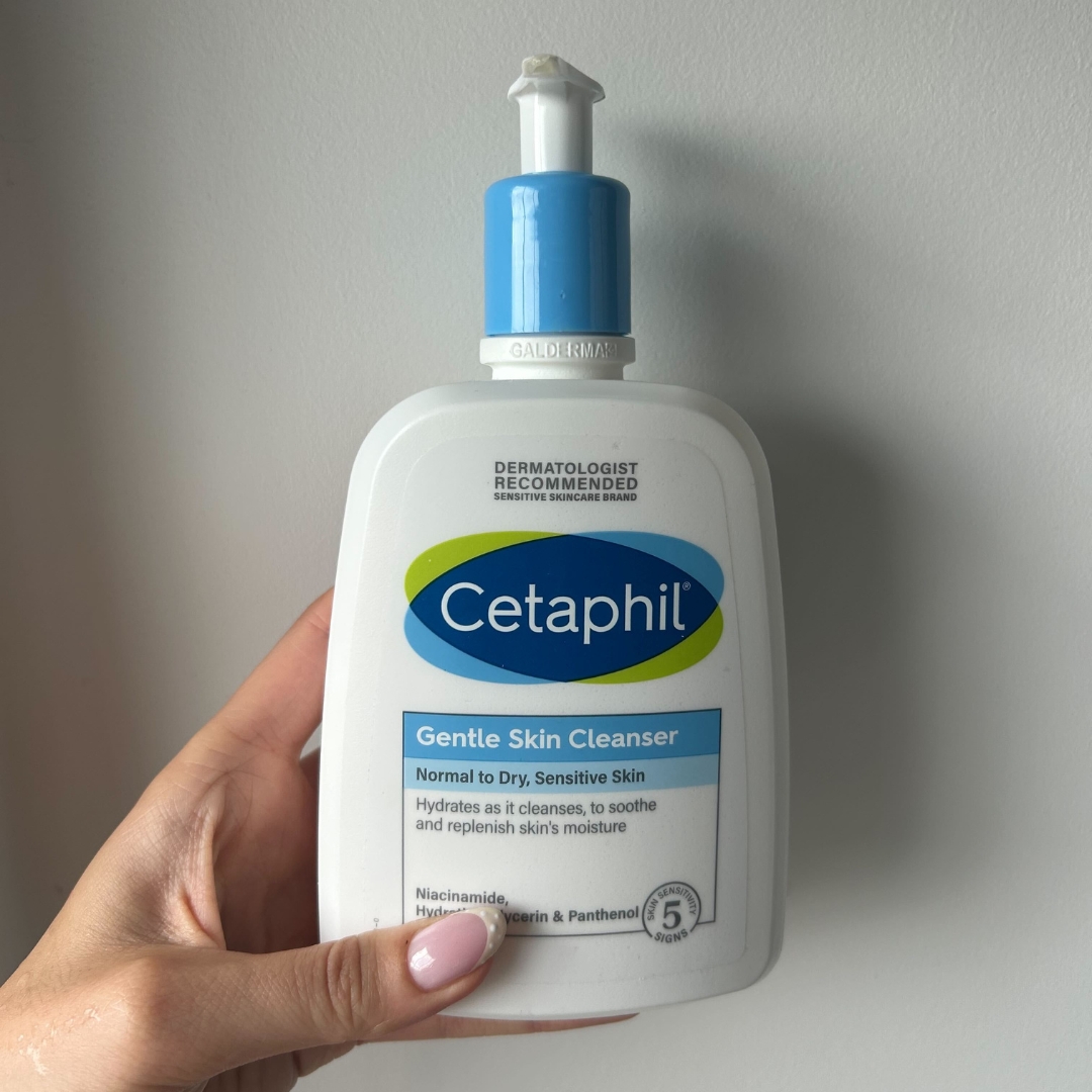 Hand holding a bottle of Cetaphil Gentle Skin Cleanser