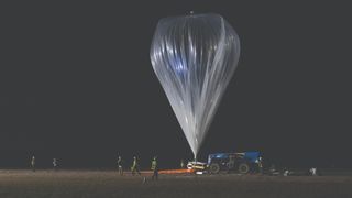 A large silver balloon inflating to lift to the Spaceship Neptune
