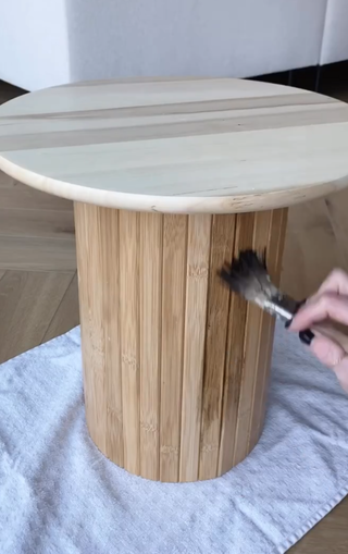 A side table being painted with a wood stain
