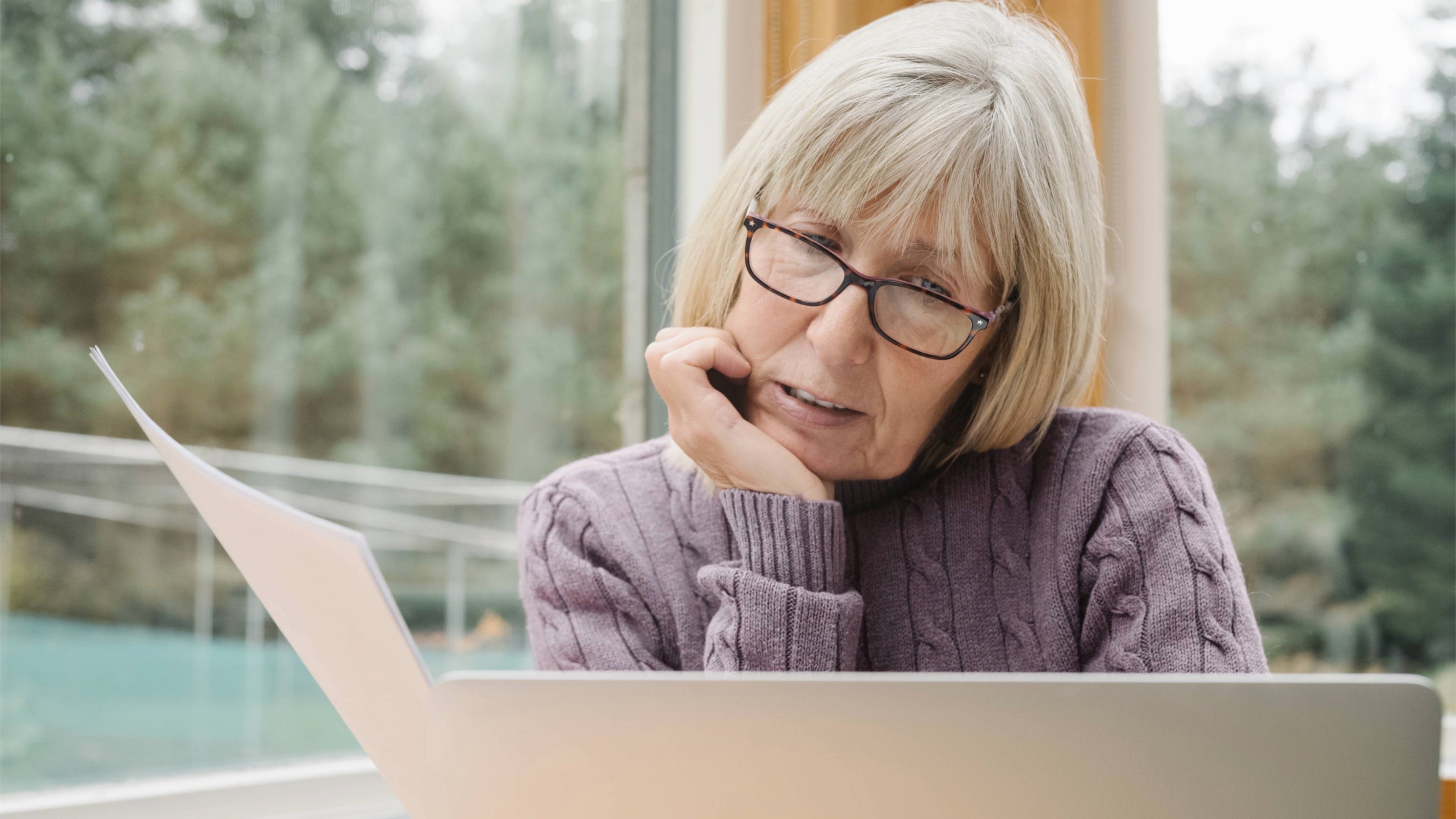Worried senior woman examining a bill 