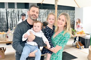 Jimmy Kimmel carrying his son Billy and Molly McNearney carrying their daughter Jane