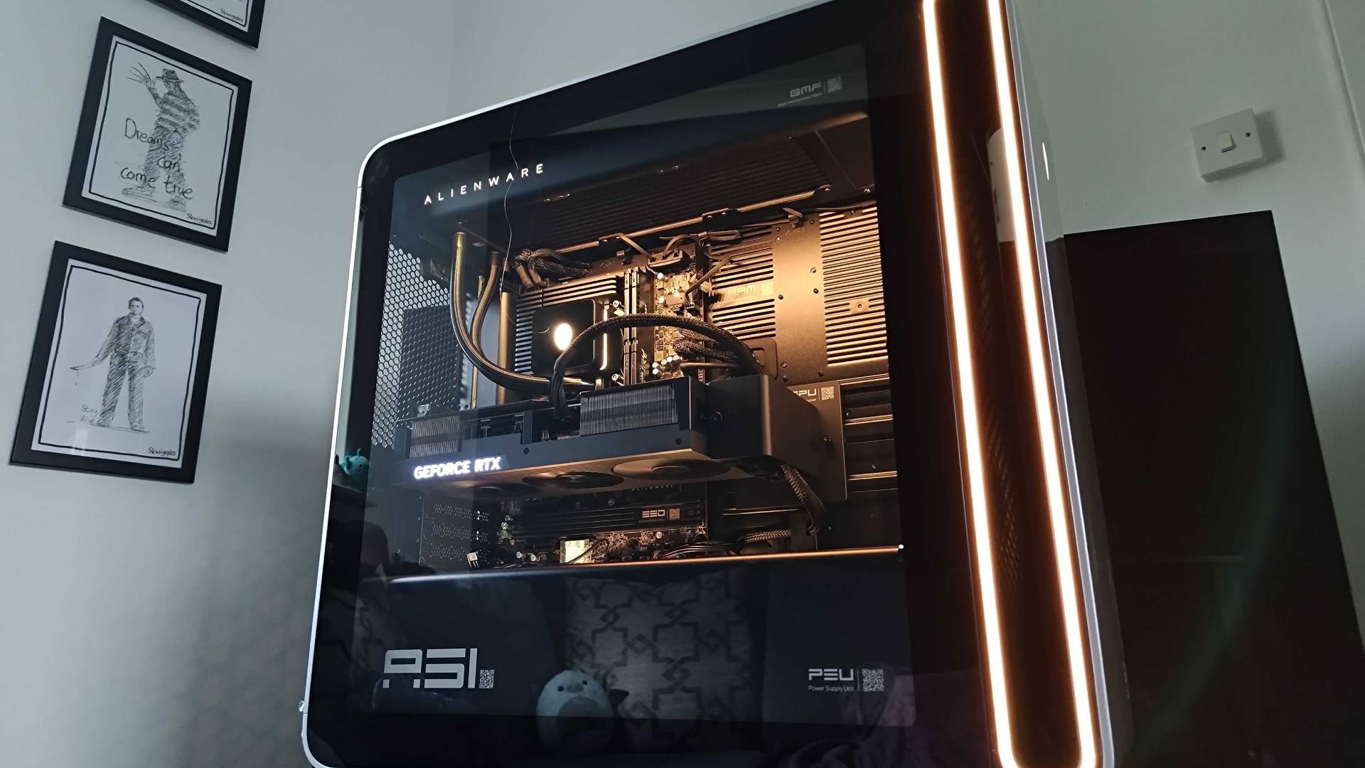 Close up of Alienware Area-51 side panel with yellow RGB lights inside.