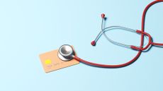 Conceptual image of a stethoscope on top of a credit card, illustrating ideas around the health of one's credit
