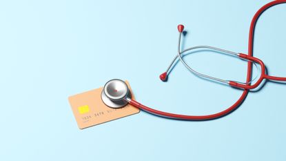 Conceptual image of a stethoscope on top of a credit card, illustrating ideas around the health of one's credit