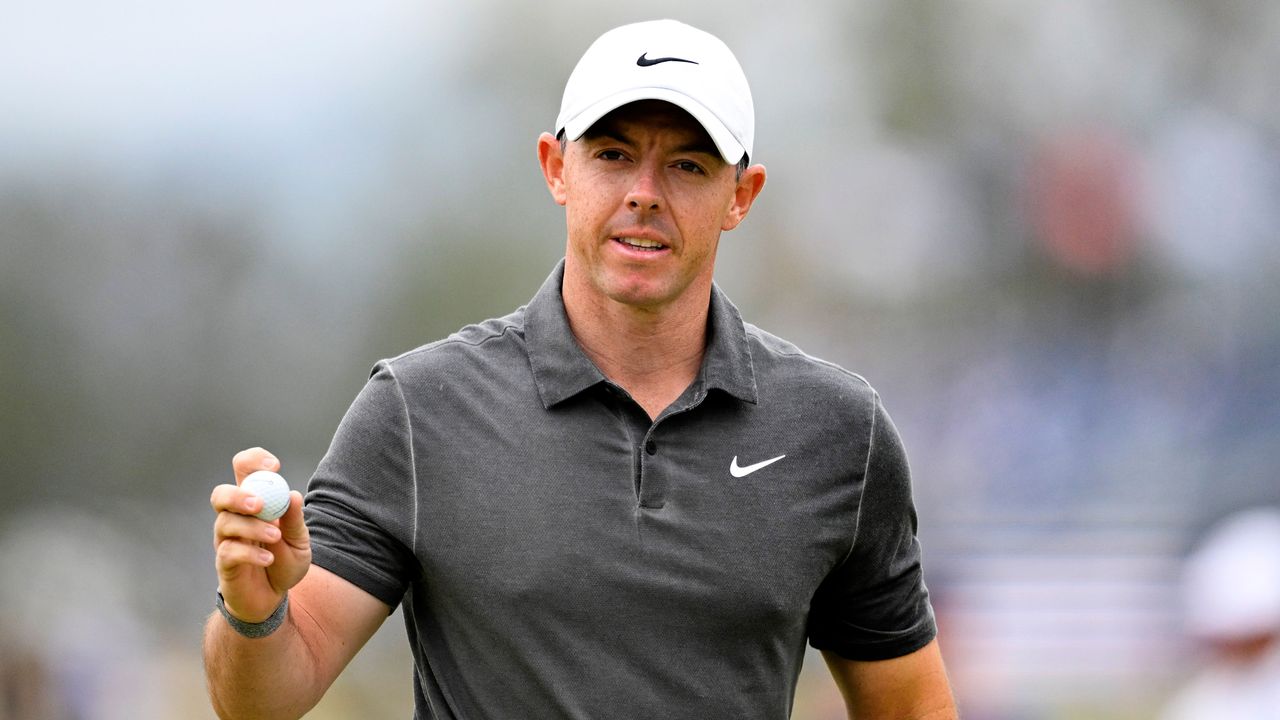 McIlroy salutes the crowd holding his ball after holing a putt at the 2023 US Open