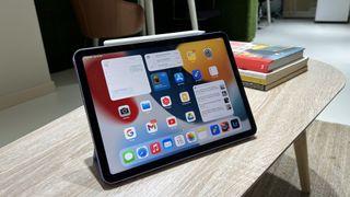 En Apple iPad Air 5 står på ett skrivbord med hemskärmen aktiv.