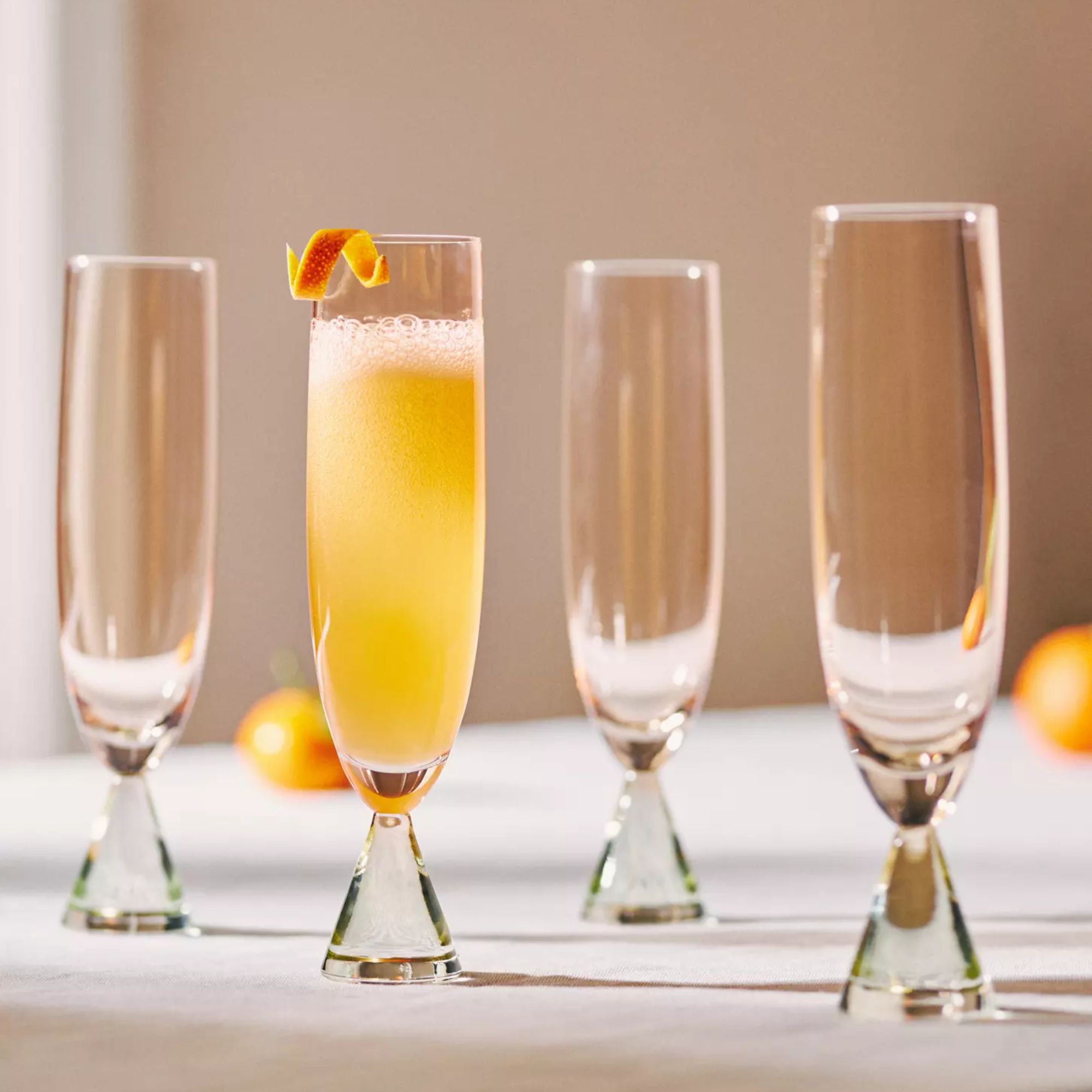 Glass flutes with cone-shaped stems and a peach-colored body