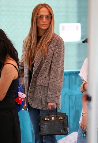 Jennifer Lopez wearing a plaid blazer jeans and a birkin bag in los angeles