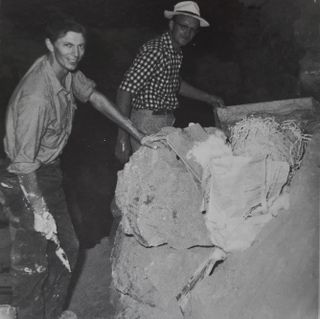 Part of Ralph Solecki's team that excavated the remains of the 10 Neanderthal men, women and children who were discovered in Shanidar Cave in the 1950s. Here, T. Dale Stewart (right) and Jacques Bordaz (left) move the remains of the so-called "flower burial" "en bloc" ("all together") from the cave. This block was later found to hold the partial remains of three more Neanderthals.