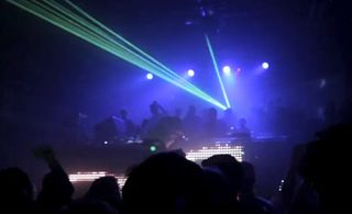 Nightclub dancefloor with DJ and strobe lights