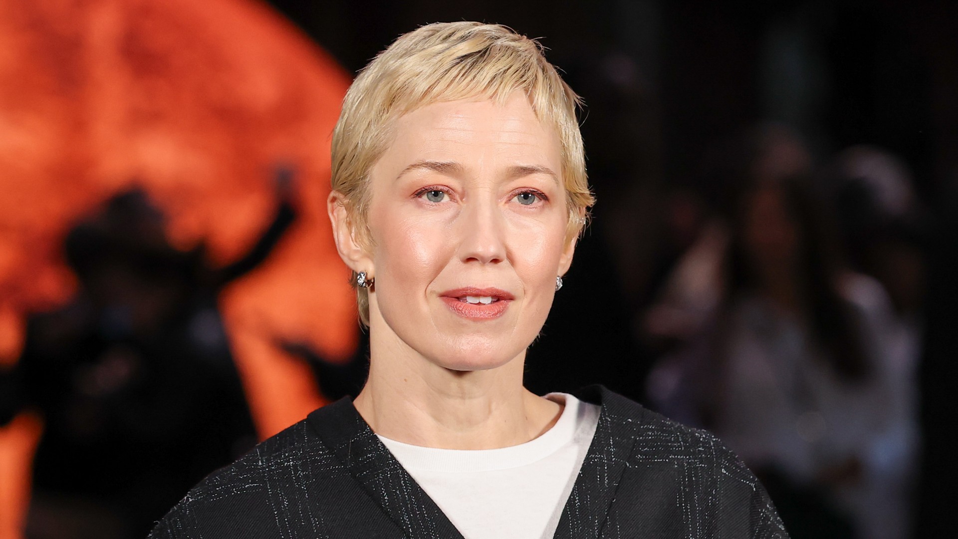 a white woman with a short, blonde haircut poses for paparazzi during a fashion week event