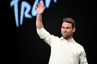 British cyclist Mark Cavendish waves as he arrives on stage for the 2025 Tour de France and the 2025 Tour de France Femmes (women) routes' presentation in Paris on October 29, 2024. The Tour de France Men's race will start in Lille, northern France on July 5, 2025 (July 5 - 27) and the women's race (July 26 - August 3) will be launched in Brittany. (Photo by JULIEN DE ROSA / AFP)