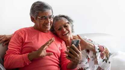 Senior couple chatting by video conference using a smart phone