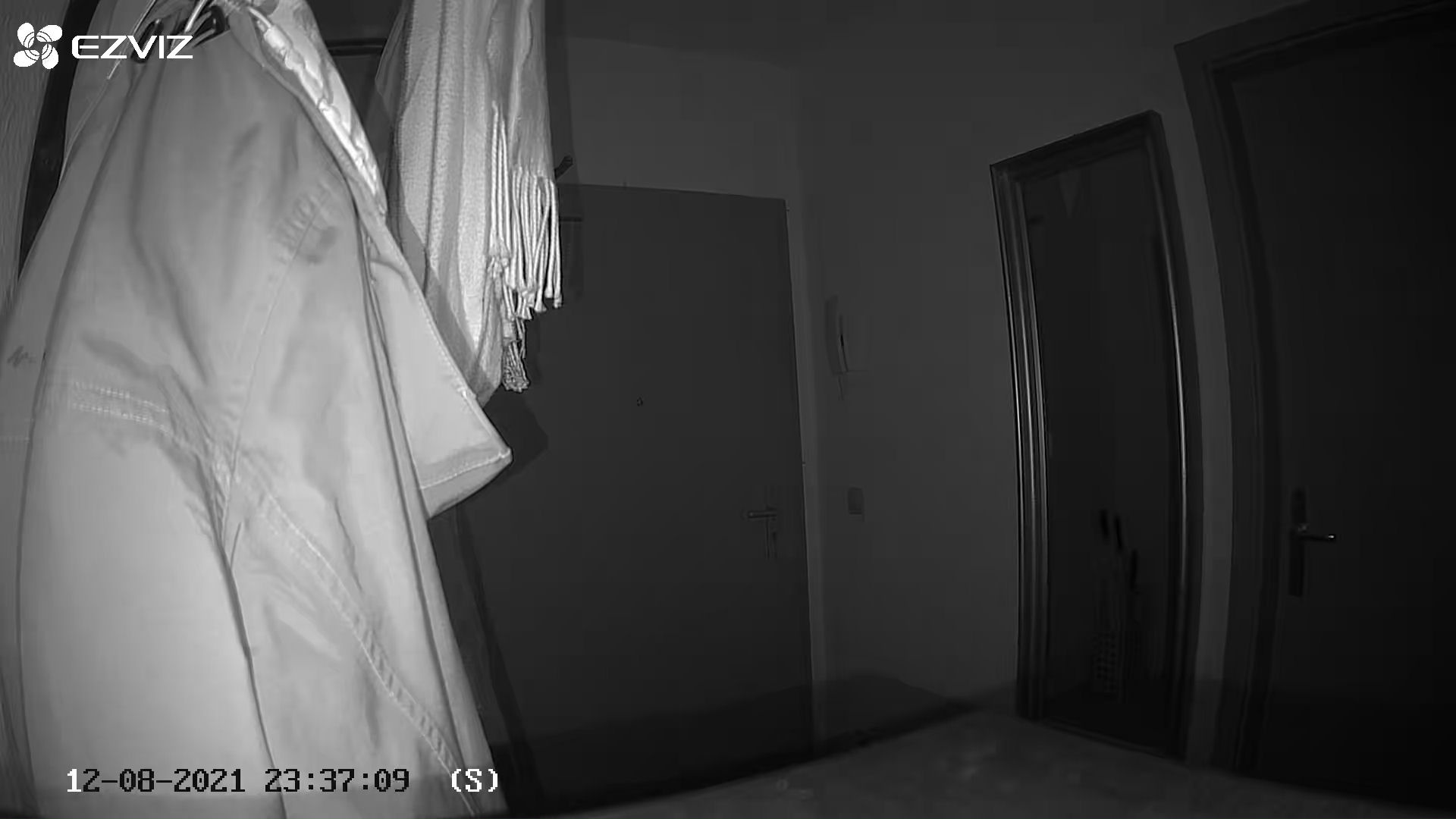 Blick auf eine Wohnungstür mit einer Überwachungskamera bei Nacht