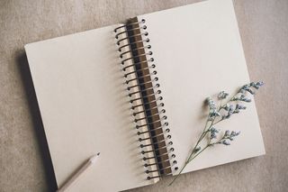 A notepad with a lavender flower on one of the pages