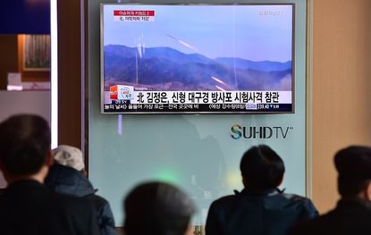 People in South Korea watch footage of North Korean rocket launches. 