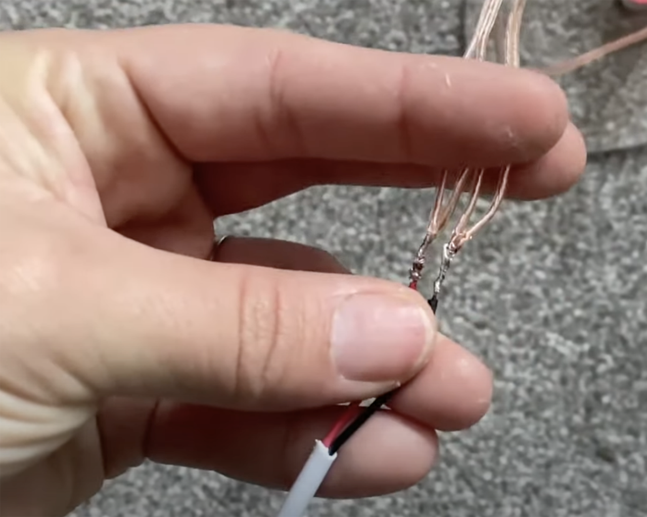 Neon rope sign DIY - Jasmine Guerney holding copper wires to demonstrate how to separate and connect all positive wires and all negative wires separately