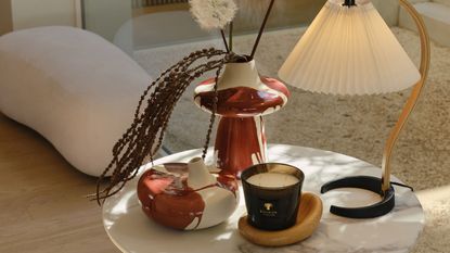 westwing vases on side table with lamp and candle, with boucle ottoman in the background with beige rug