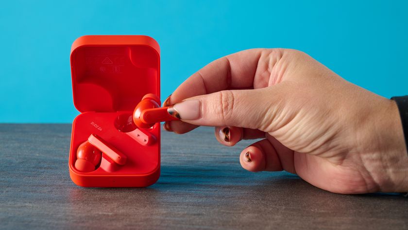 cmf buds 2a in the orange colorway photographed in front of a blue background