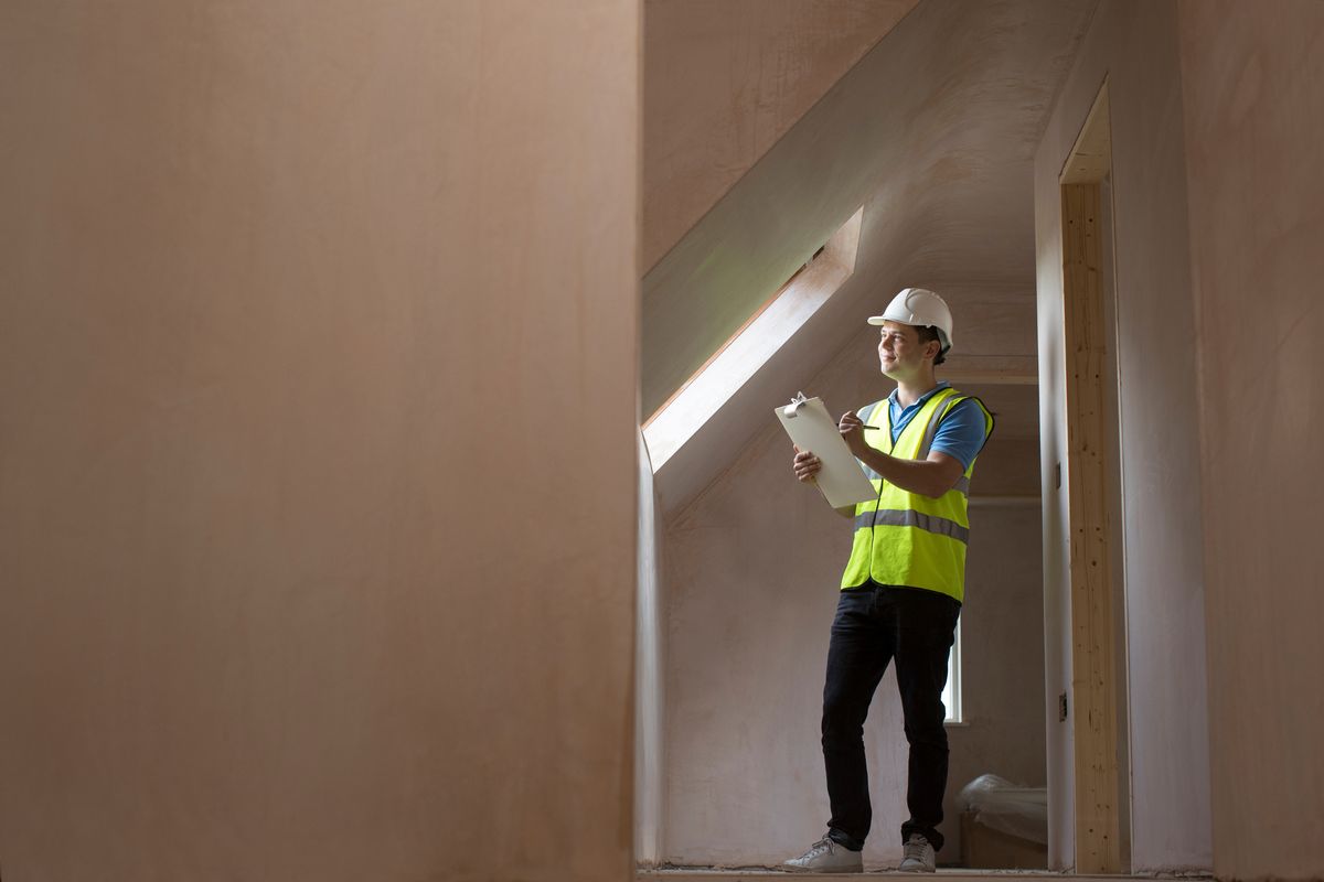 man with clipboard inspecting building