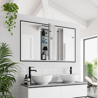 recessed cupboard with black frame, mirrors and LED light around edges on white wall with two round sinks, back taps and white and grey vanity unit