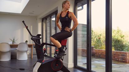 Woman cycles on the Wattbike Atom model by a window