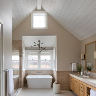 Bathroom with pitched ceiling and white bath