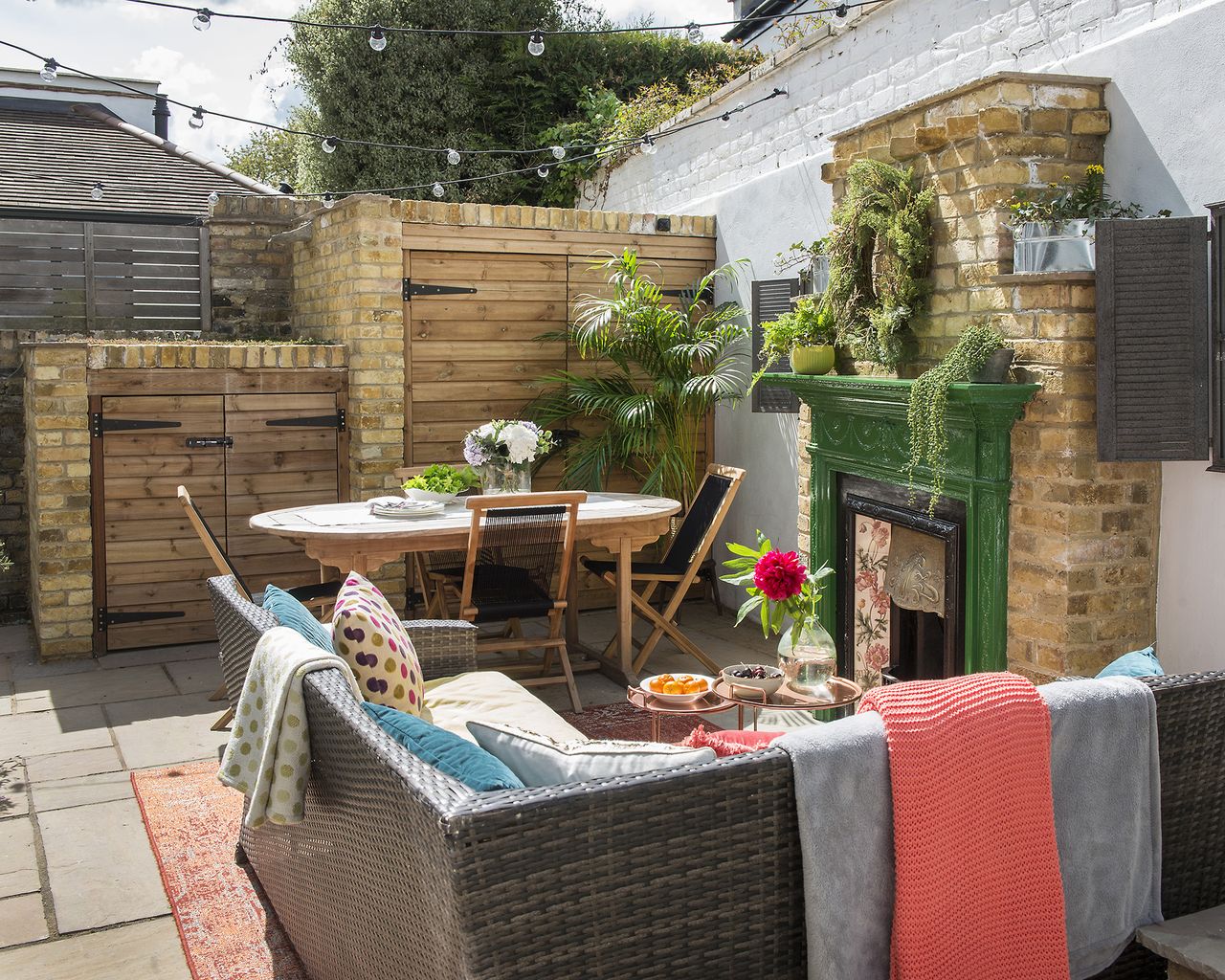 a small courtyard patio with built in storage and outdoor fireplace
