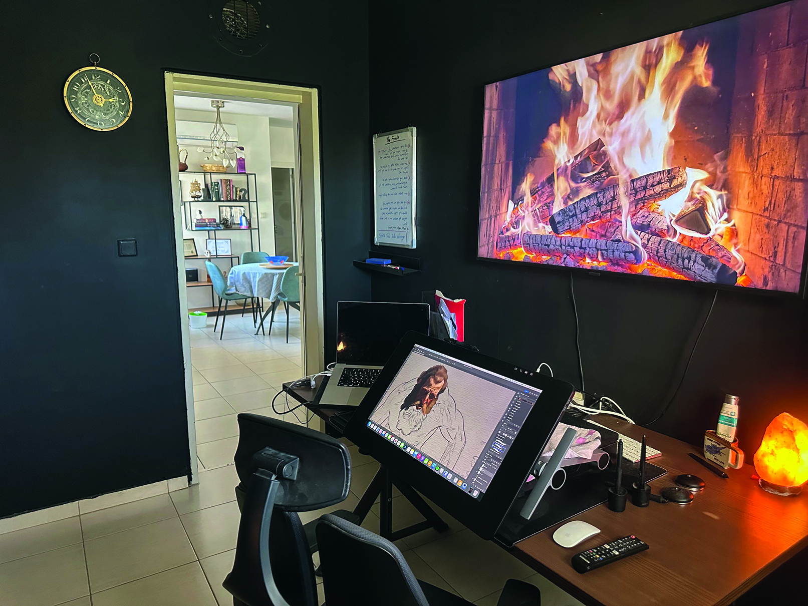 image of Aviad Sajevitch's studio - drawing tablet set up on desk with fake fire behind