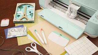 The best Cricut Explore Air 2 bundle deals; a craft cutting machine surrounded by materials