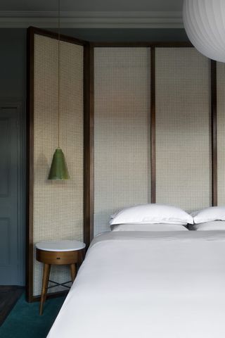 modern bedroom with rattan screen used as a headboard
