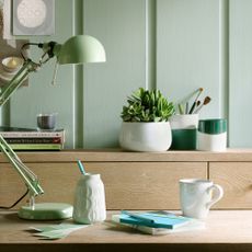 office home in sage green with anglepoise lamp and plants