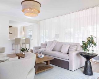 Pool house designs example, with neutral interiors, sofas, a breakfast bar and sheer white drapes.