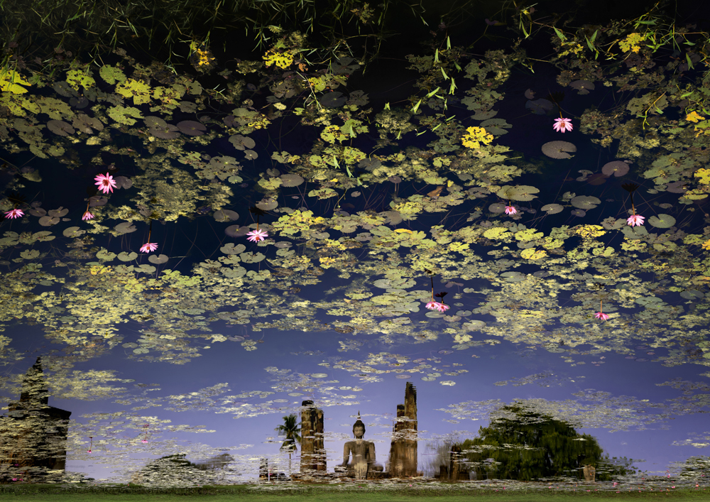 A serene pond reflects ancient statues surrounded by vibrant water lilies and lush greenery under a clear blue sky