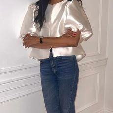 @symphonyofsilk wears a cream puff-sleeve blouse with blue jeans and black slingback shoes