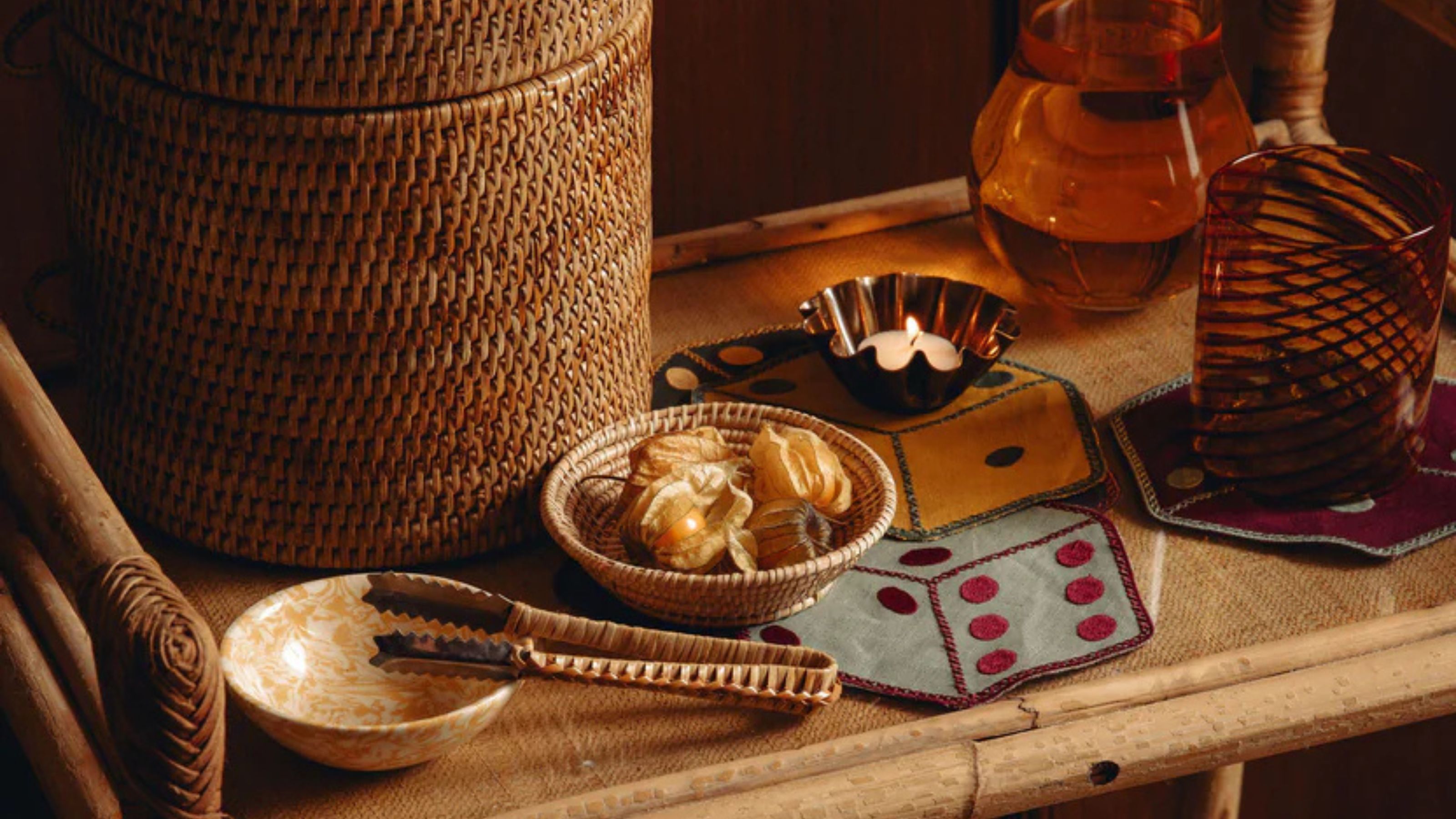 bar cart styled with rattan wine cooler, tongs, colored glassware, and dice-shaped cocktail napkins
