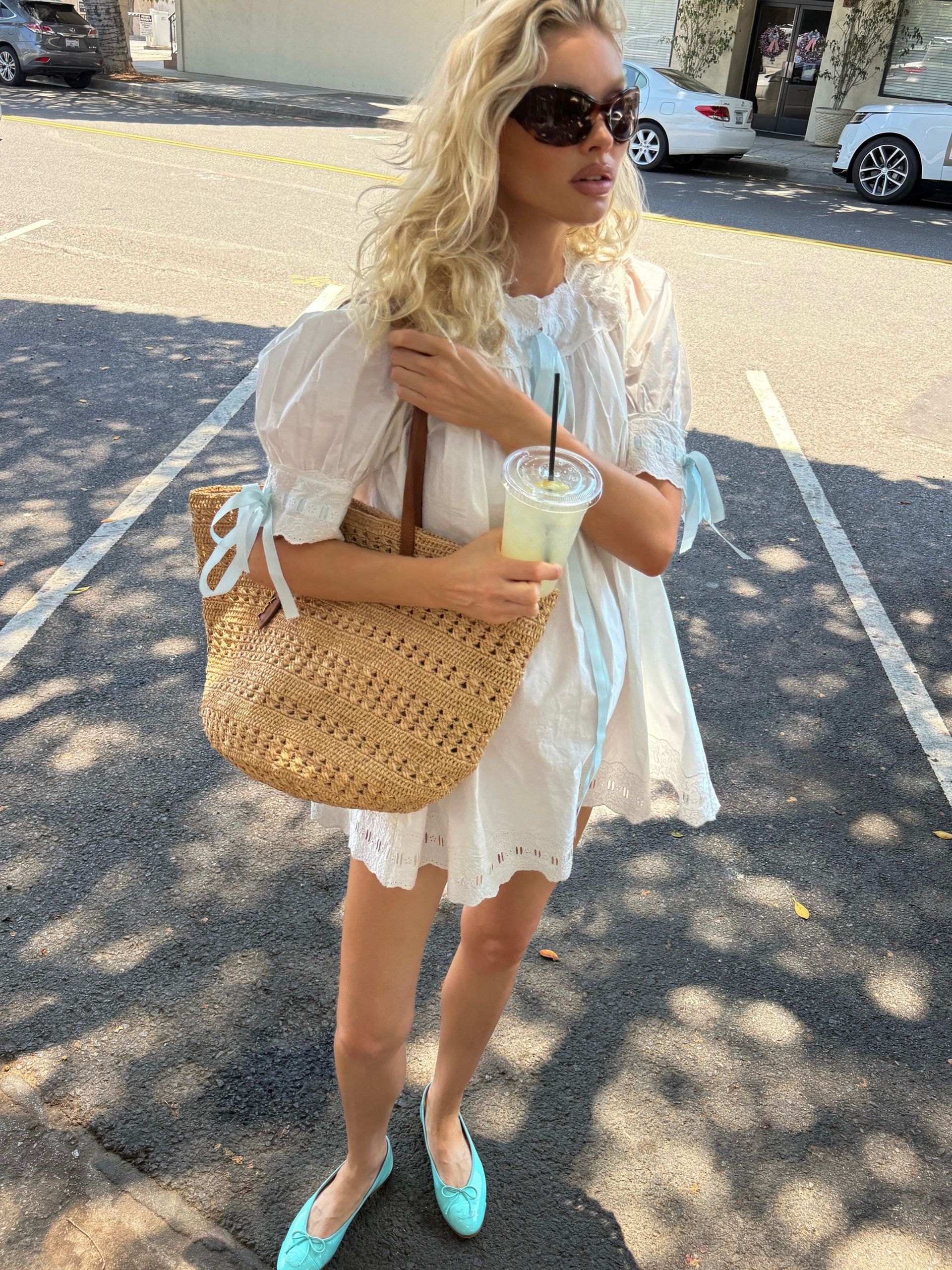 Elsa Hosk wearing a white dress and Raffia bag