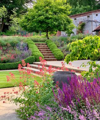 sloping garden designed with planted banks and terraces by Acres Wild Garden Design