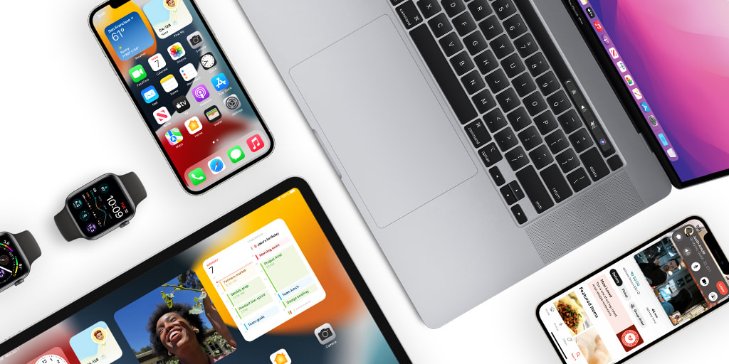 Top down image of a MacBook, iPhone, Apple Watch, and iPad on a white background